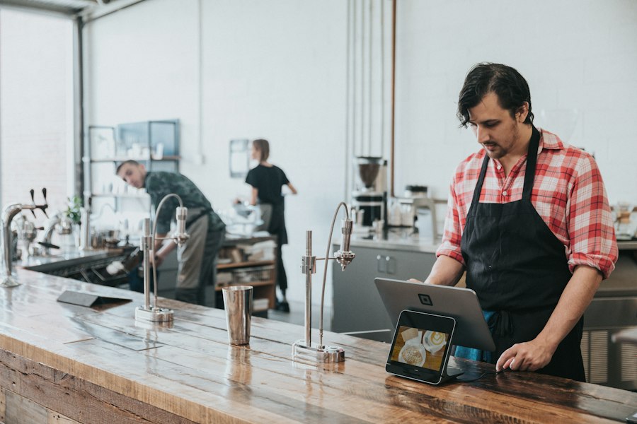A barista at a counter with a tablet register